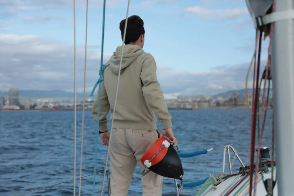 A sailor holding his Morphéis anchor alarm attached to the buoy